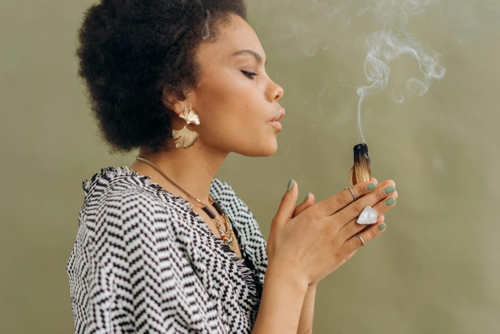 Jeune femme participant à un rituel paisible avec du Palo Santo, se concentrant sur la relaxation et la tranquillité.